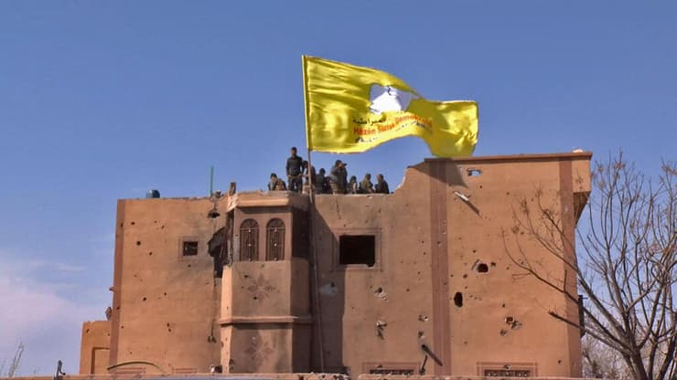 הכוחות הסוריים הדמוקרטיים (SDF) מניפים את דגלם אחרי כיבוש מוצב של דאעש ב-2019 (צילום: AFP) כוחות סורים מניפים דגל אחרי כיבוש מוצב של דאעש