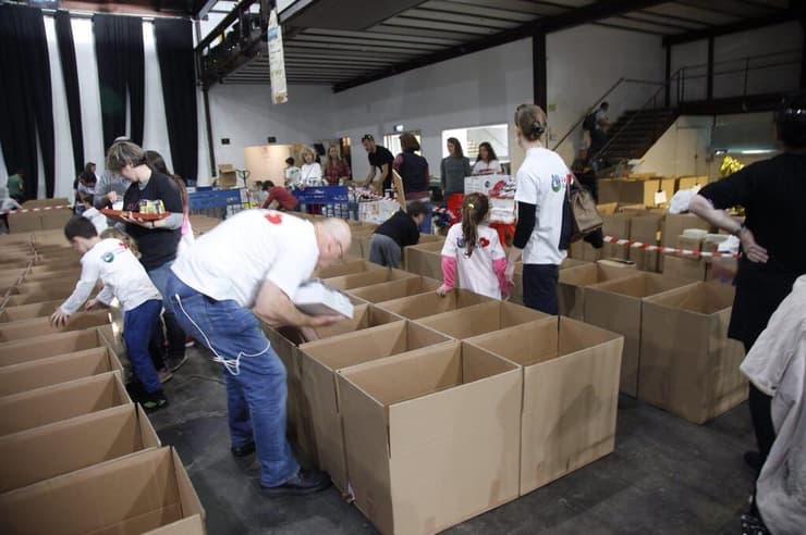 מתנדבים לאריזת חבילות מזון למשפחות נזקקות לקראת חג הפסח בהאנגר 11 בנמל תל אביב
