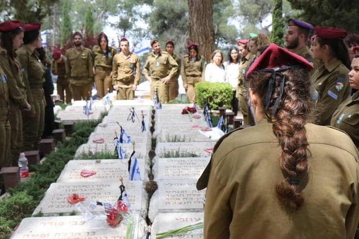 חיילים עומדים על קברי חללים בהר הרצל ביום הזיכרון לחללי צה"ל