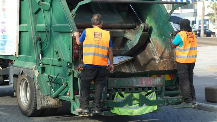משאית זבל בפעולה (צילום: shutterstock) משאית זבל בפעולה