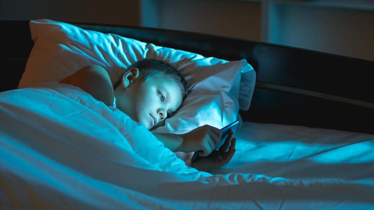 ילד מתכונן לשינה עם טלפון חכם (אילוסטרציה: Shutterstock) ילד מתכונן לשינה עם טלפון חכם