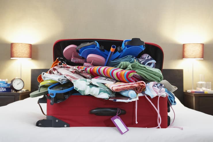 מזוודה מתפקעת עקב אריזת יתר (צילום: shutterstock) מזוודה מתפקעת עקב אריזת יתר