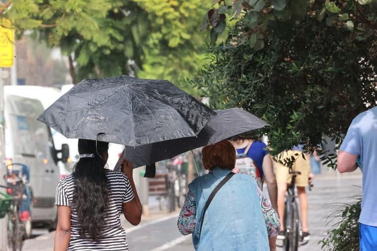 עם מטריות בתל אביב, ארכיון (צילום: מוטי קמחי) גשם קל בתל אביב