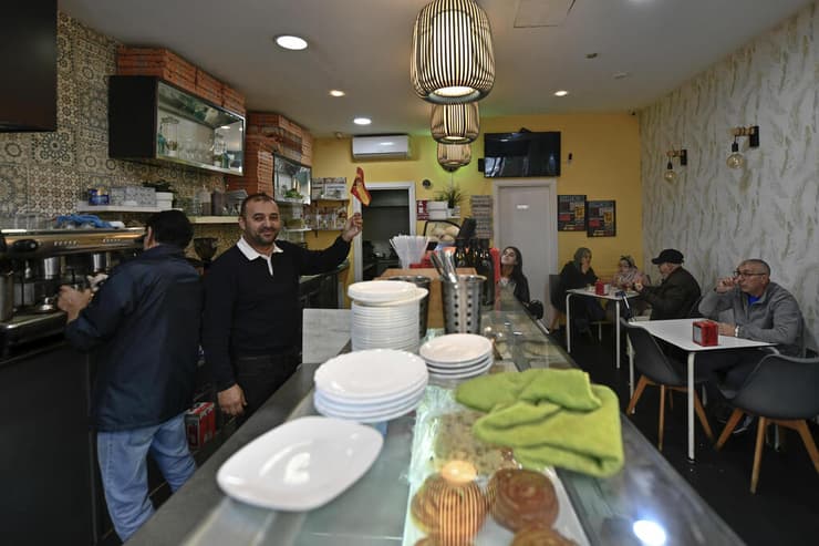 העיקר ליהנות. עובד בבר בסאוטה מנופף בדגל ספרד (צילום: AP ) ספרד סאוטה מובלעת ב אפריקה גבול מרוקו לקראת שמינית גמר ה מונדיאל