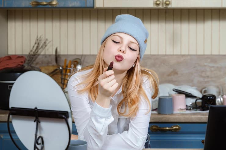 נערה בלוגרית מתאפרת מול המצלמה