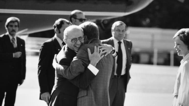 נשיא ארה"ב ג'ימי קרטר חיבוק עם ראש ממשלת ישראל מנחם בגין קמפ דייוויד 1978 משקיפה אשתו רוזלין