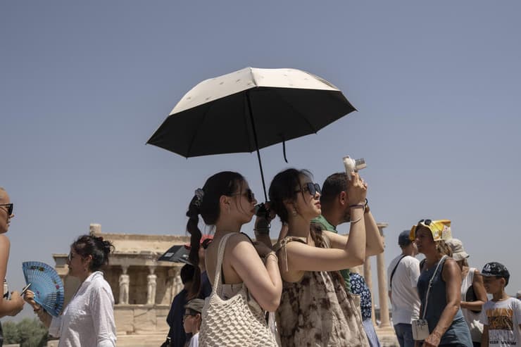 מתגוננים מהשמש באקרופוליס, אתונה (צילום: AP Photo/Petros Giannakouris) מתגוננים מהשמש באקרופוליס, אתונה