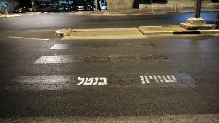 כתובות שרוססו במעבר חצייה בהרצליה (צילום: תא אמנות המחאה הרצליה) הכתובות שרוססו במעבר החצייה בהרצליה