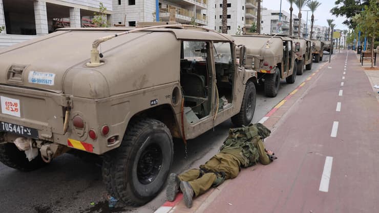 "כמו ברווזים במטווח". חייל תופס מחסה ליד כלי רכב, ארכיון (צילום: Menahem KAHANA / AFP) תופסים מחסה בשדרות