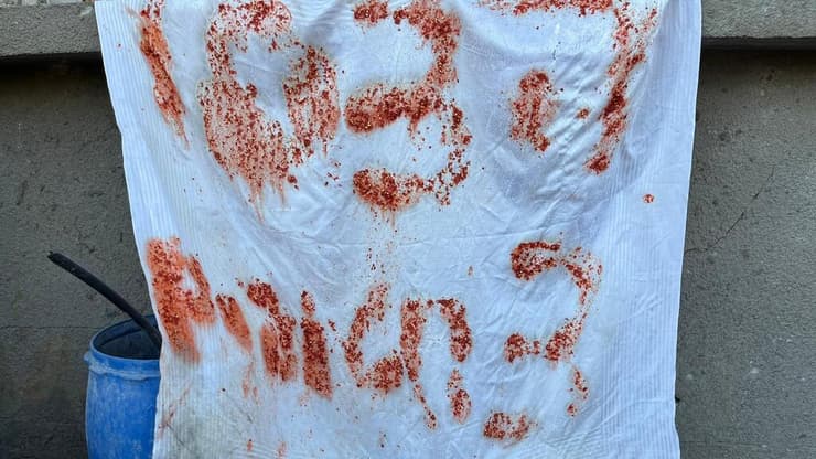 שלטים עם קריאות לעזרה ברצועת עזה, בסמוך לאירוע בו נורו החטופים הישראלים על ידי כוחות צה"ל