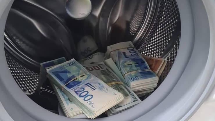 הלבנת הון בשווי 60 מיליון שקלים (צילום: דוברות המשטרה ) כסף שהוחבא בתוך מכונת כביסה