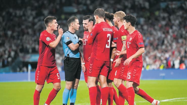 שחקנים מתגודדים סביב השופט