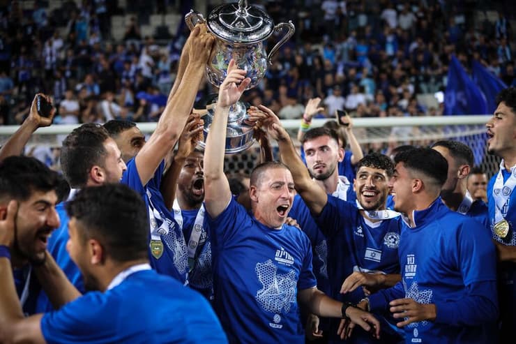 כבר יודע איך זה לזכות בגביע. קוז'וך ושחקני מכבי פ"ת חוגגים בעונה שעברה (צילום: עוז מועלם) מאמן מכבי פ"ת רן קוז'וך ושחקניו חוגגים לאחר הזכייה בגביע המדינה
