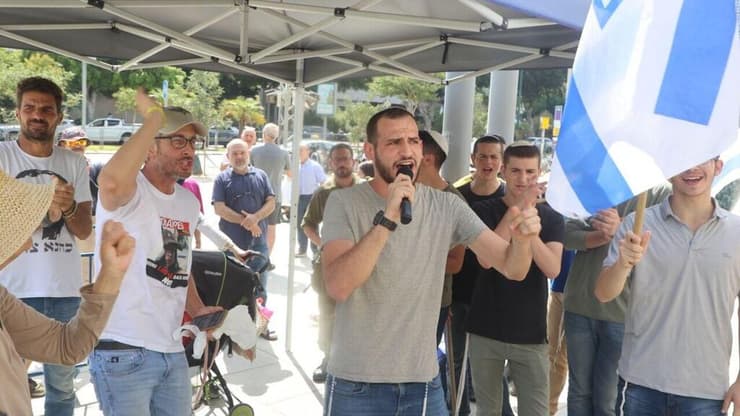 הפגנת תמיכה בחשוד שהואשם. ״הפכו ילד גיבור לחשוד ברצח״ (צילום: מוטי קמחי) אנשים מתגודדים מחוץ לבית משפט השלום בת"א בתמיכה בחייל שנשפט בחשד להוצאה להורג של מחבל נוחבה