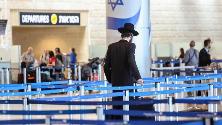 חשש מ"פרצות" באכיפת איסור היציאה מהארץ (צילום: GIL COHEN-MAGEN / AFP) נוסע חרדי בשדה התעופה נתב"ג, עת היערכות לתקיפה איראנית