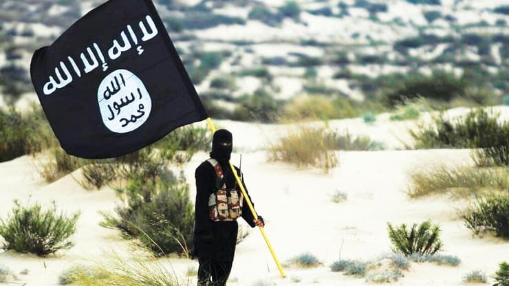 אחד הנערים התכוון לבצע פעולת טרור בהשראת דאעש. ארכיון (צילום: GettyImages) פעיל דאעש עם דגל ארגון הטרור