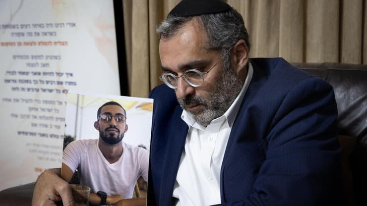 "תהיה פגישה מרגשת". הרב אלחנן דנינו עם תמונת בנו אורי (צילום: אלכס קולומויסקי) אלחנן דנינו עם תמונת בנו, אורי ז"ל