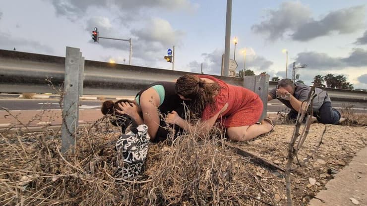 תופסים מחסה בצד הכביש בזמן אזעקה בצפון (צילום: יואב קרן) אזעקה ליד עכו
