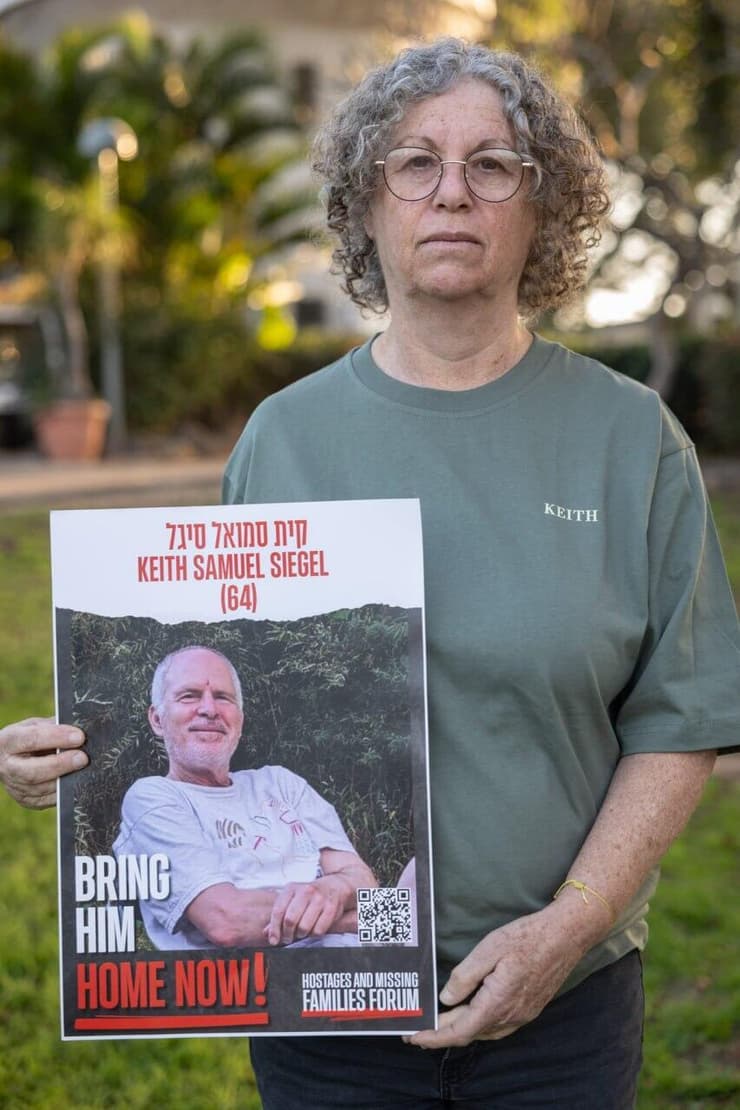 אביבה סיגל ששוחררה מהשבי עם תמונתו של בעלה קית' 