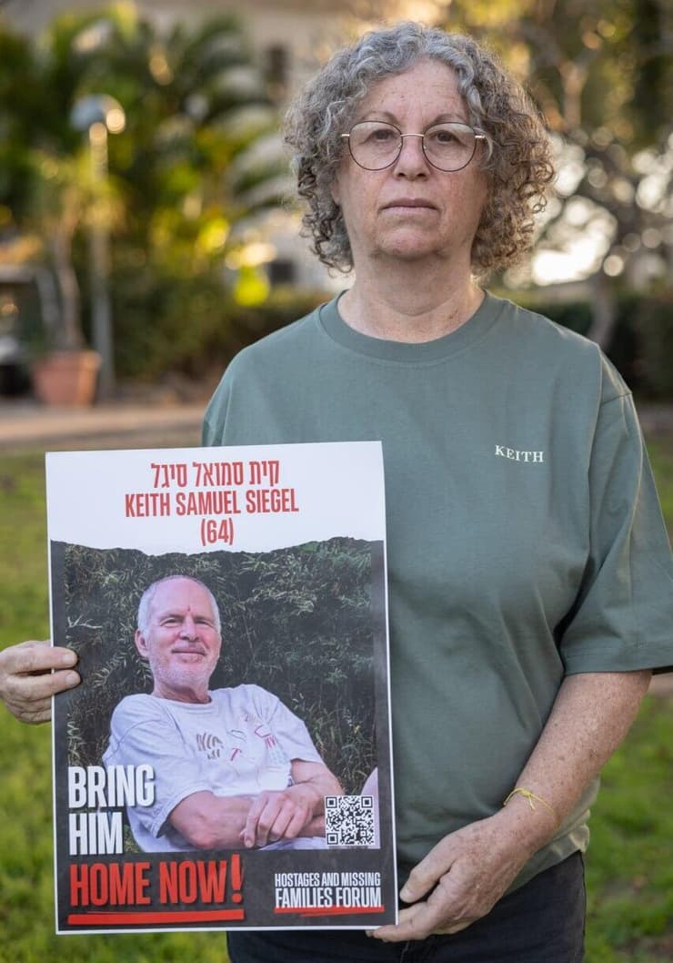 אביבה סיגל ששוחררה מהשבי עם תמונתו של בעלה קית' 