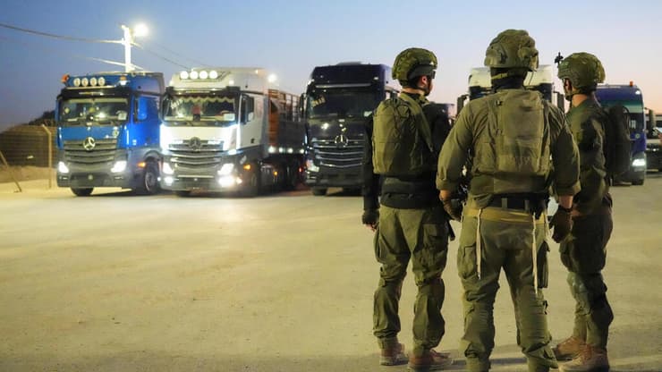 חיילי צה"ל מאבטחים משאיות סיוע ברצועה (צילום: REUTERS/Janis Laizans) חיילי צה"ל מאבטחים את משאיות הסיוע ההומנטרי ברצועת עזה