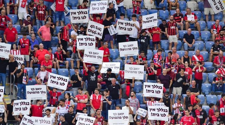 אוהדי הפועל חיפה מניפים שלטים נגד כץ (חגי מיכאלי, one) אוהדי הפועל חיפה מניפים שלטים נגד כץ