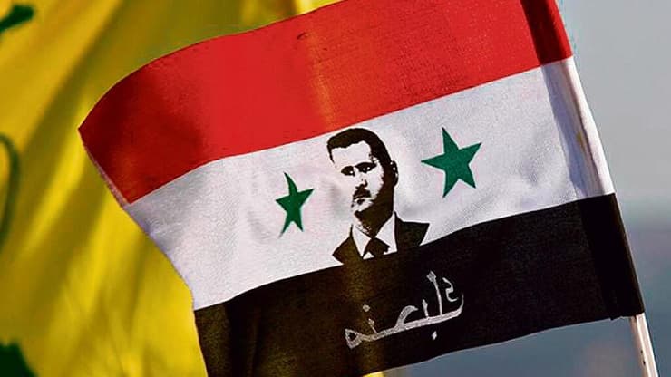 דגל סוריה עם תמונת בשאר אל-אסד עם הכיתוב: "אוהבים אותך", בהפגנת הזדהות עם חיזבאללה בדמשק