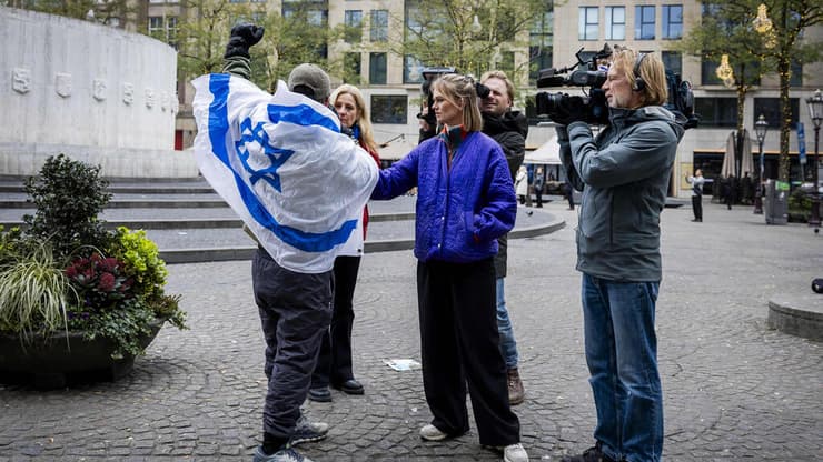 אדם עם דגל ישראל מתראיין לתקשורת הולנדית