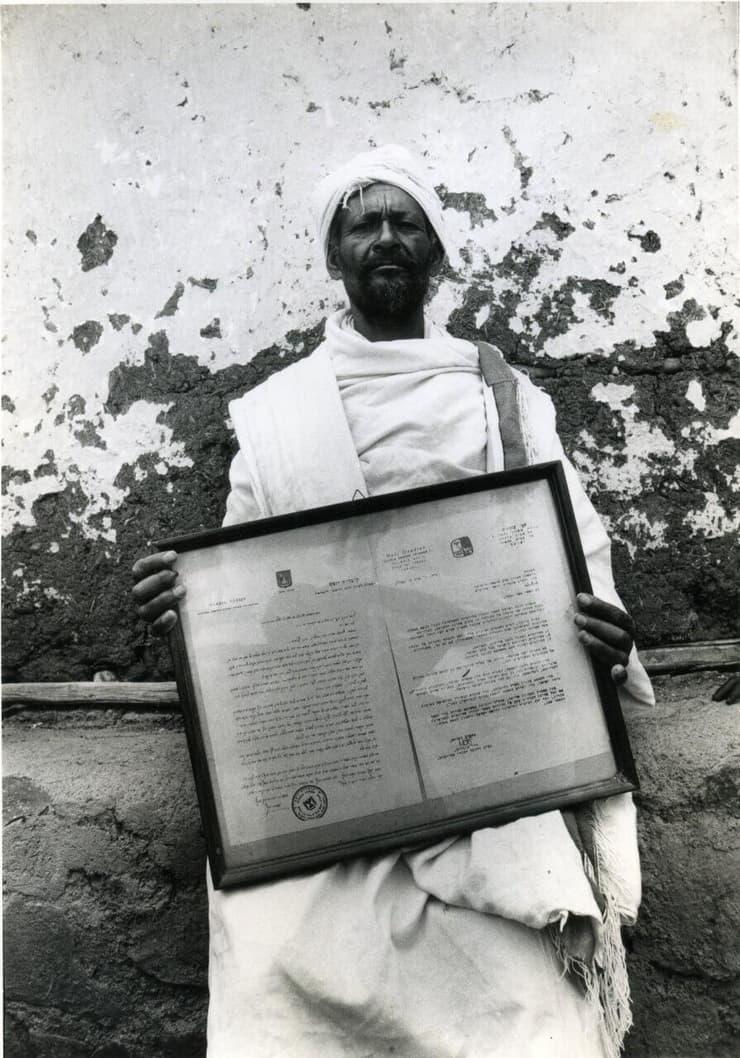 קס שגיאה באיינה  מחזיק בידו מכתב מאת הרב עובדיה יוסף שקבע בשנת 1975 כי העולים מאתיופיה הם יהודים. התמונה צולמה ב-1984