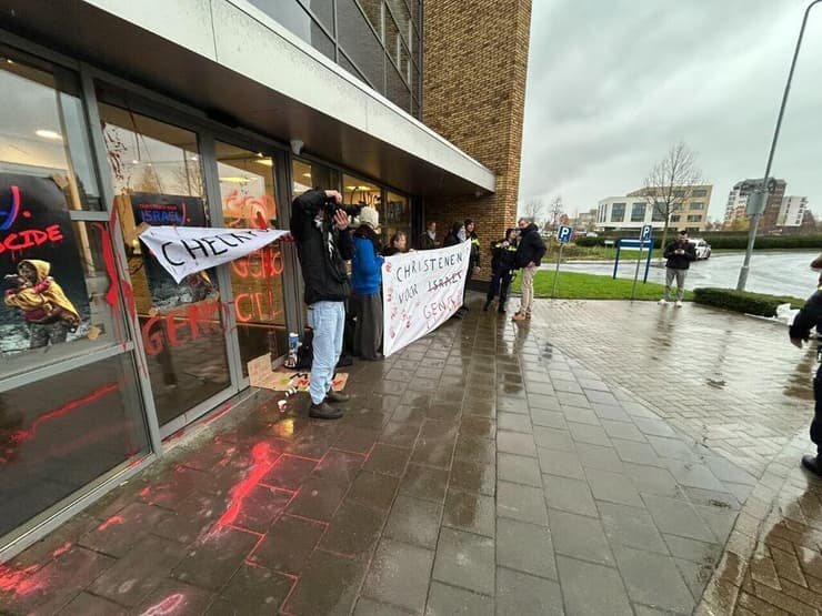 המפגינים מחזיקים שלטים נגד הארגון (צילום: אלכסנדר בלום) המפגינים מחזיקים שלטים נגד הארגון