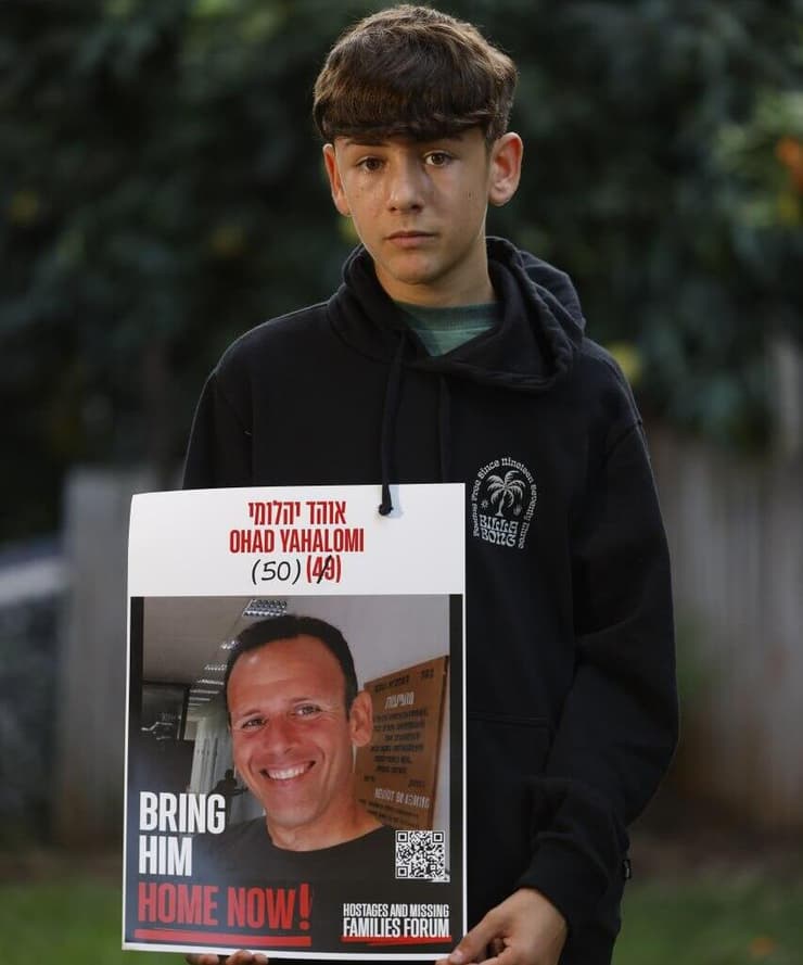 איתן יהלומי בחייו החדשים. מחזיק תמונה של אביו שבשבי