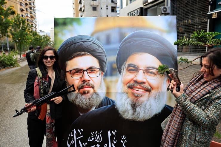 עם נשק ותמונות של נסראללה. תומכי חיזבאללה בביירות (צילום: REUTERS/Thaier Al-Sudani) ביירות