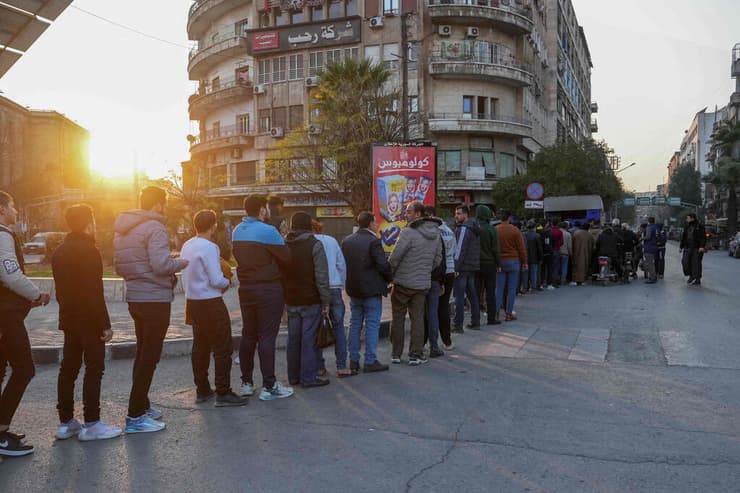 תור ללחם בחלב שנכבשה על-ידי מורדים ג'יהאדיסטים. "אנחנו באי-ודאות" (צילום: MUHAMMAD HAJ KADOUR / AFP) תור ללחם בעיר חלב שנכבשה על ידי מורדים ב אסד ב סוריה