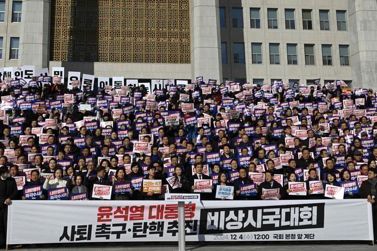 מחוקקים מהאופוזיציה בדרום קוריאה עם שלטים הקוראים להתפטרות הנשיא יון סוק יאול ב סיאול
