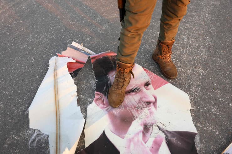 "חזינו שאסד יצליח לשרוד את ההתקוממות, לפחות בטווח בינוני" (צילום: Mohammed AL-RIFAI / AFP) מורד ב חמה דורך על תמונת דיוקנו של נשיא סוריה בשאר אל אסד