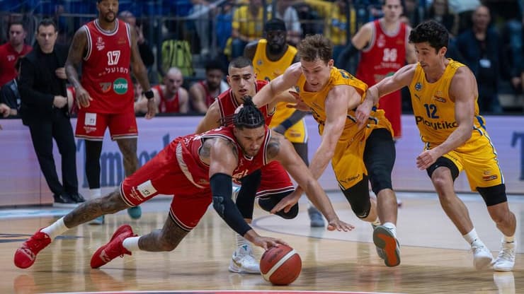 כל הרעש הזה בשביל דרבי בינוני? (צילום: טל שחר) שחקן הפועל ת"א איש וויינרייט מול שחקן מכבי ת"א רוקאס יוקובאיטיס, ג'ון דיברתולומיאו