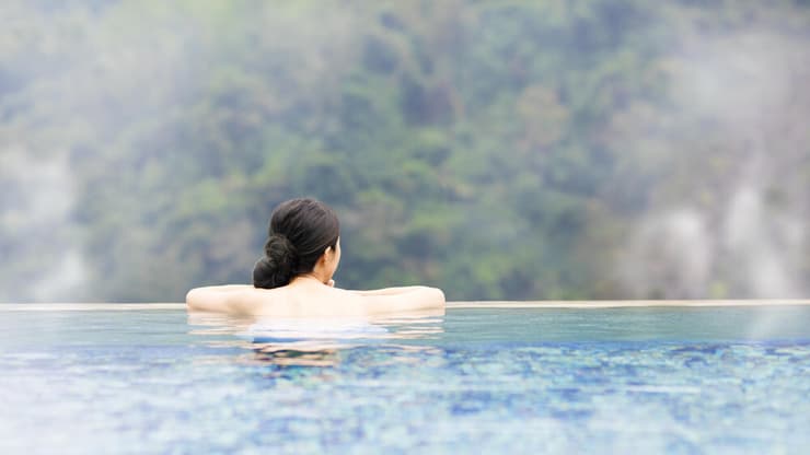 אישה צעירה נרגעת במעיינות חמים