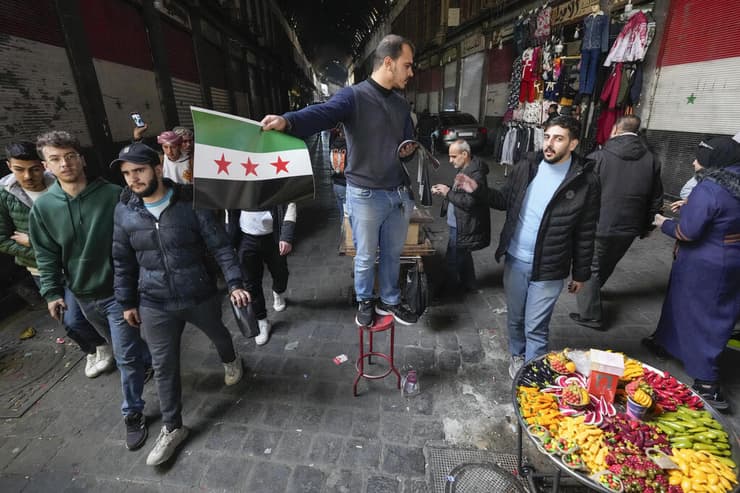 מניפים את דגלי האופוזיציה בשוק של דמשק (צילום: AP / Hussein Malla) מניפים את דגלי האופוזיציה ב דמשק סוריה