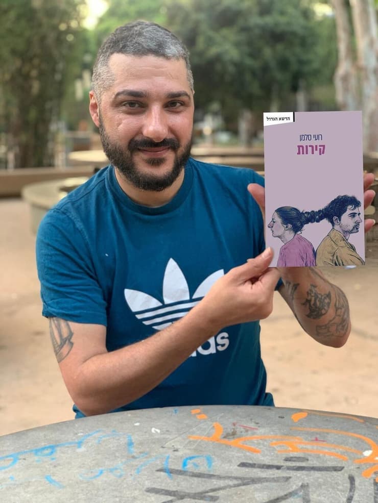 רועי סלמן עם ספרו החדש "קירות". שלושה סיפורים שנוגעים בקשר משולש ובפגיעה מינית (צילום: אלבום פרטי) רועי סלמן עם ספרו החדש "קירות"