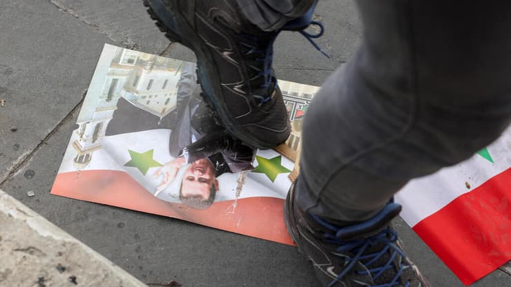 דורכים על תמונתו של אסד בדמשק לאחר הפלת המשטר (צילום: REUTERS/Mohamed Azakir) דמשק