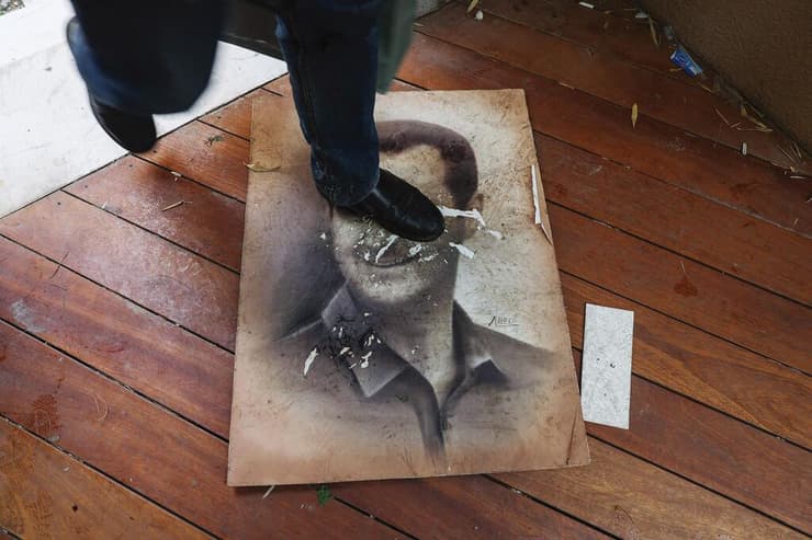 אדם דורך על תמונתו של בשאר אל-אסד עם כניסת המורדים לארמון בדמשק