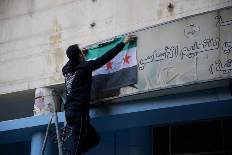 תולים את דגל סוריה החדשה הבוקר בבית ספר בדמשק (צילום: Ali Haj Suleiman/Getty Images) סוריה חזרה ל לימודים אחרי משטר אסד בית ספר דמשק