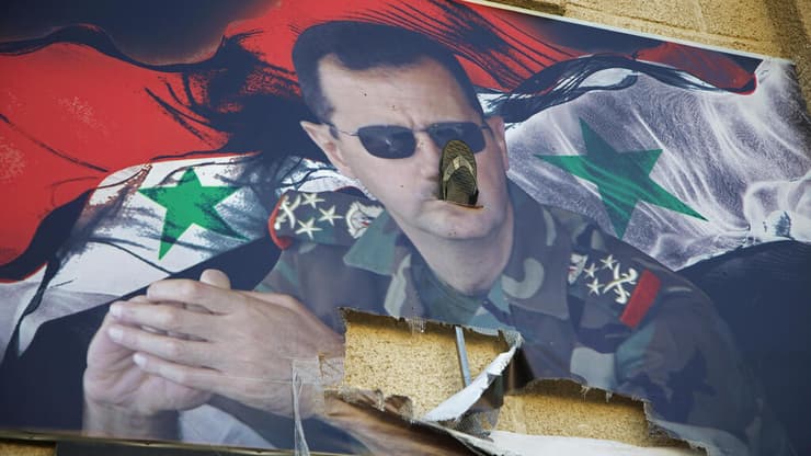 תמונה קרועה של נשיא סוריה לשעבר בשאר אל-אסד בכלא מזה