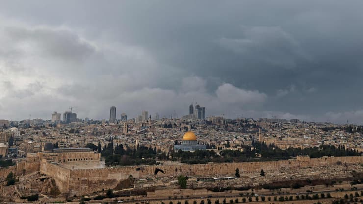 מזג אוויר חורפי בירושלים (צילום: AHMAD GHARABLI / AFP) גשם בעיר העתיקה ירושלים