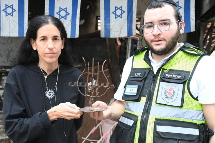 בתה של שפרה ז"ל, דורית נוי, עם ישראל חסיד איש זק"א מחזיקים את החנוכייה