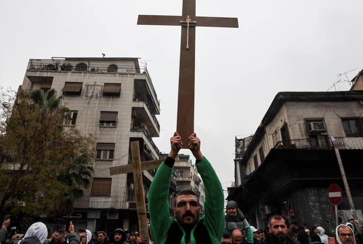 "דורשים זכויות, די לאי-צדק". מפגינים עם צלב בדמשק, היום (צילום: REUTERS/Amr Abdallah Dalsh) הפגנה ב דמשק סוריה נגד הצתת עץ חג המולד