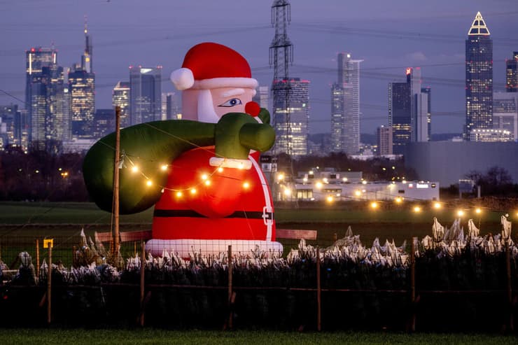 סנטה קלאוס מתנפח גדול מקשט את הדוכן של סוחר עצי חג המולד בפאתי פרנקפורט,