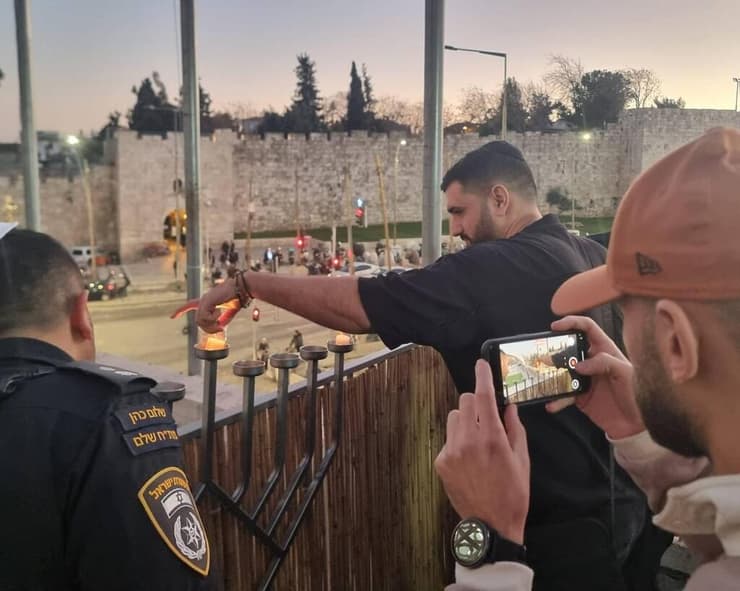 השוטר רס"ם אופיר חג'בי מדליק נר חנוכה (צילום: דוברות המשטרה) השוטר רס"ם אופיר חג'בי מדליק נר חנוכה