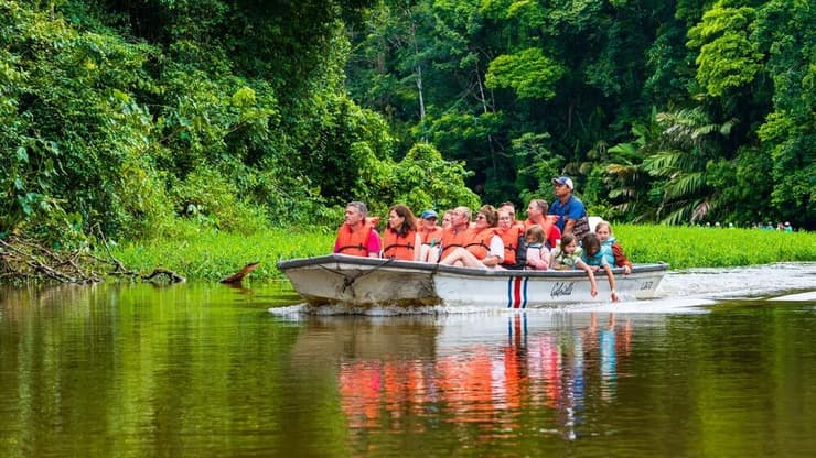 תיירים בסירה חוקרים את יער נהר טורטוגרו (צילום: Marco Lissoni / shutterstock) תיירים בסירה חוקרים את יער נהר טורטוגרו