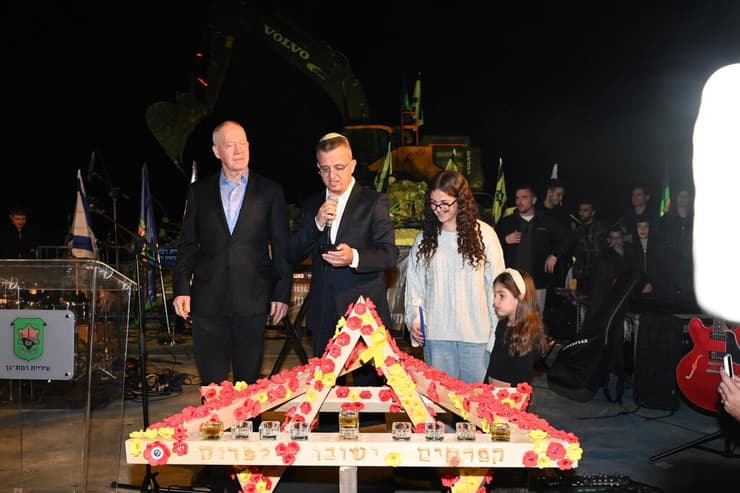 יואב גלנט וכרמל שאמה הכהן מדליקים נר ראשון של חנוכה על הריסות בית הספר ״רמת אפעל״